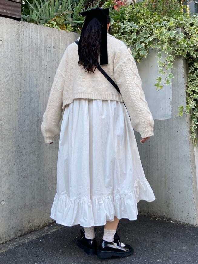 ホワイト系のカーディガン/ボレロ、ブラック系のパンプス、ブラック系のショルダーバッグを着用したレディースの冬コーディネートの2枚目の写真