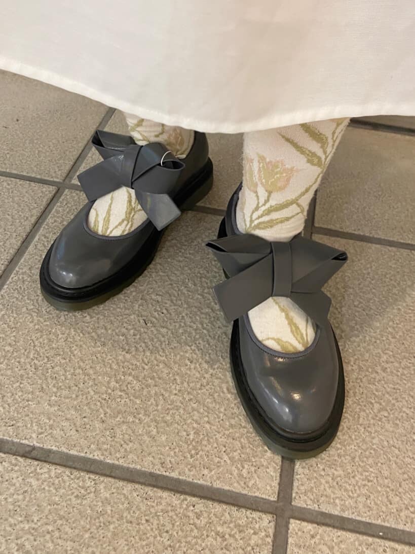 ブラック系のその他アウター、ホワイト系のワンピース、グレー系のパンプスを着用したレディースの秋コーディネートの8枚目の写真