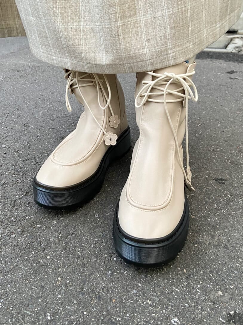 ホワイト系のブーツ、ホワイト系のハンドバッグ、ベージュ系のワンピースを着用したレディースの冬コーディネートの7枚目の写真