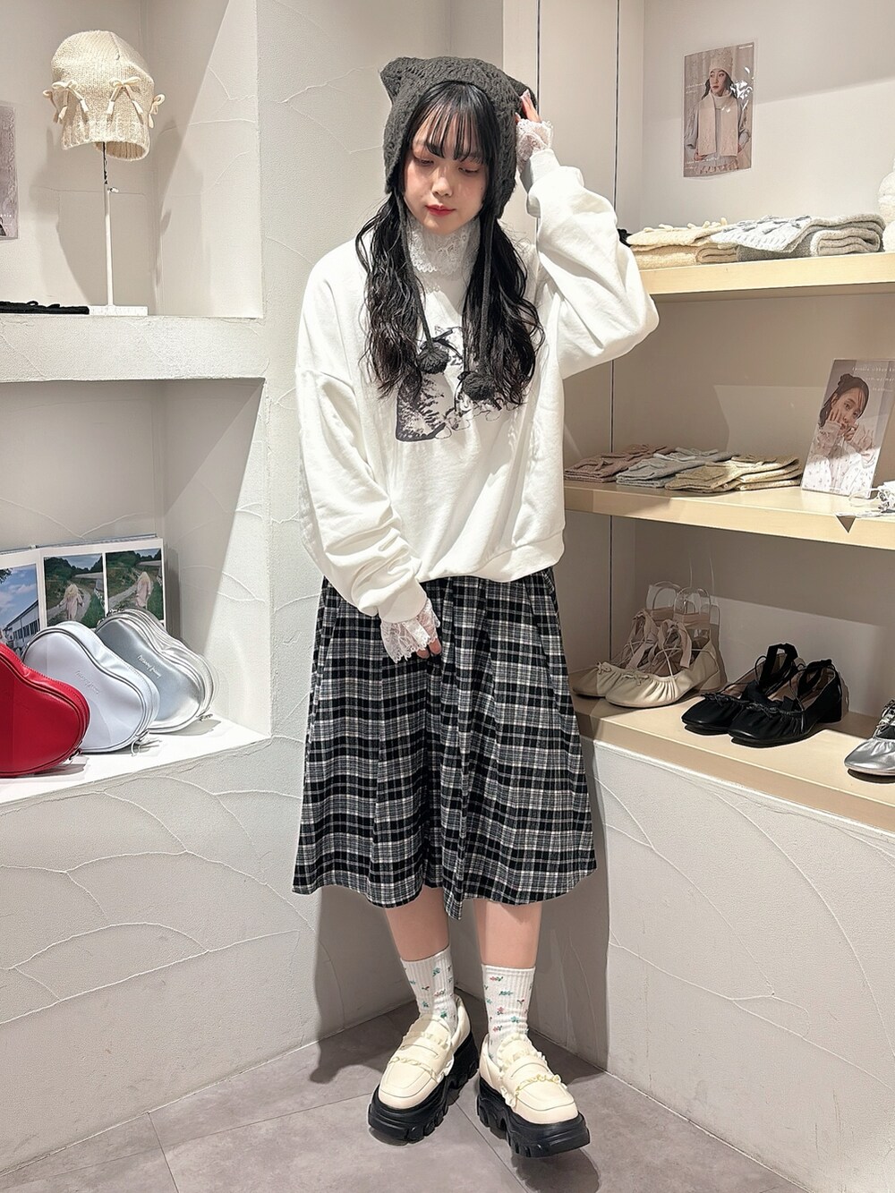 ホワイト系のニット/セーター、ホワイト系のスウェット、ブラック系のスカートを着用したレディースの秋コーディネートの3枚目の写真