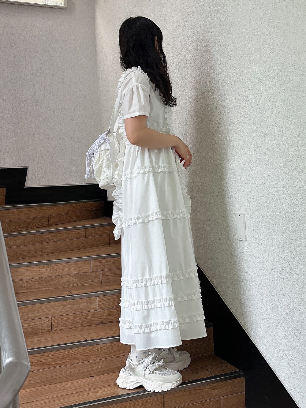 ホワイト系のスニーカー、ホワイト系のワンピース、ホワイト系のショルダーバッグを着用したレディースの夏コーディネートの3枚目の写真