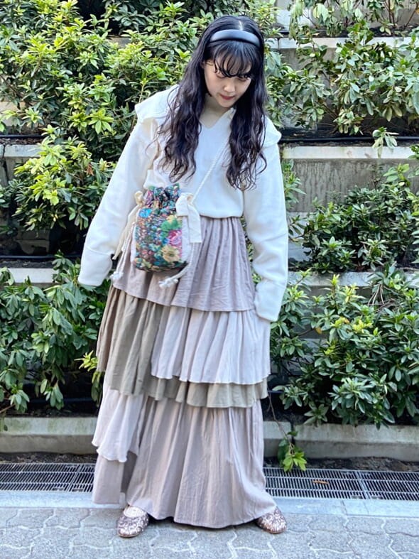 ブラウン系のスカート、ゴールド系のその他シューズ、ホワイト系のニット/セーターを着用したレディースの秋コーディネートの2枚目の写真