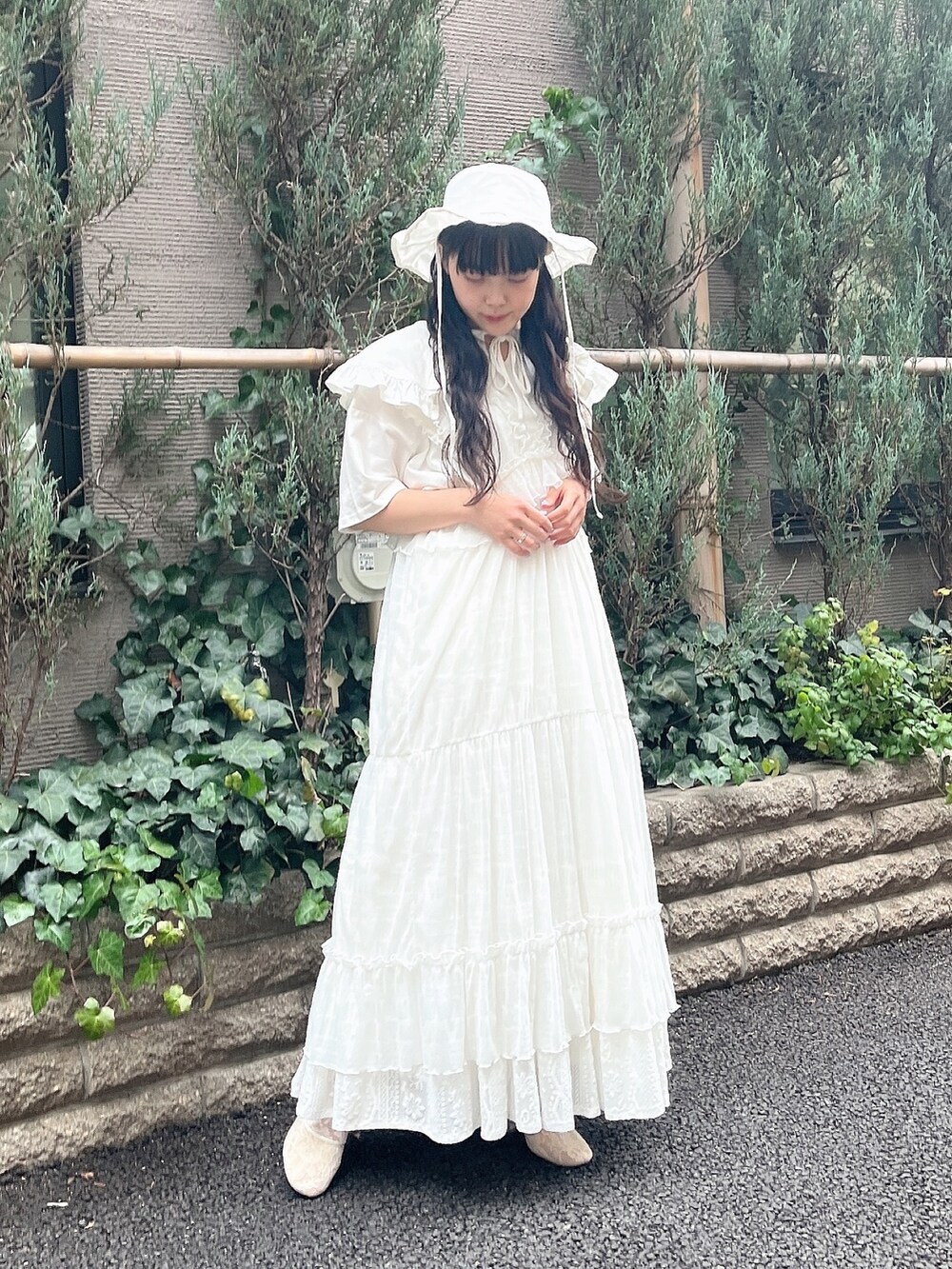 ホワイト系のパンプス、ホワイト系のワンピース、ホワイト系のTシャツ/カットソーを着用したレディースの春コーディネートの2枚目の写真