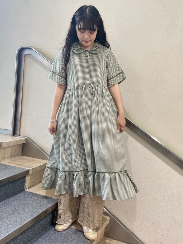 グリーン系のワンピース、ベージュ系のパンプス、ホワイト系のその他パンツを着用したレディースの夏コーディネートの2枚目の写真