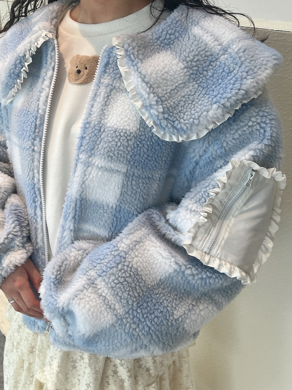 ホワイト系のスウェット、ブルー系のブルゾン、ホワイト系のスカートを着用したレディースの冬コーディネートの4枚目の写真