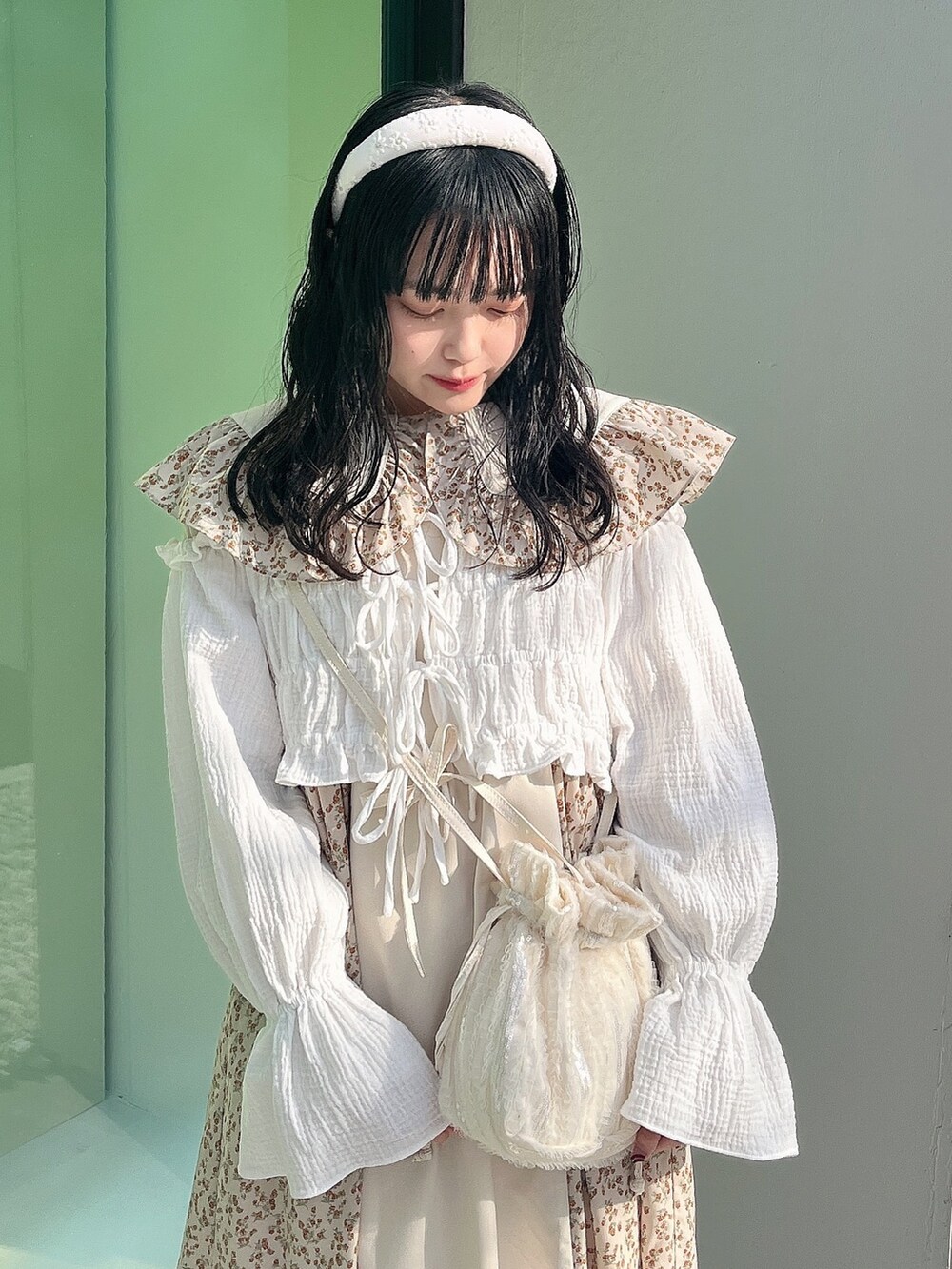 ベージュ系のワンピース、ホワイト系のシャツ/ブラウス、ホワイト系のショルダーバッグを着用したレディースの冬コーディネートの4枚目の写真