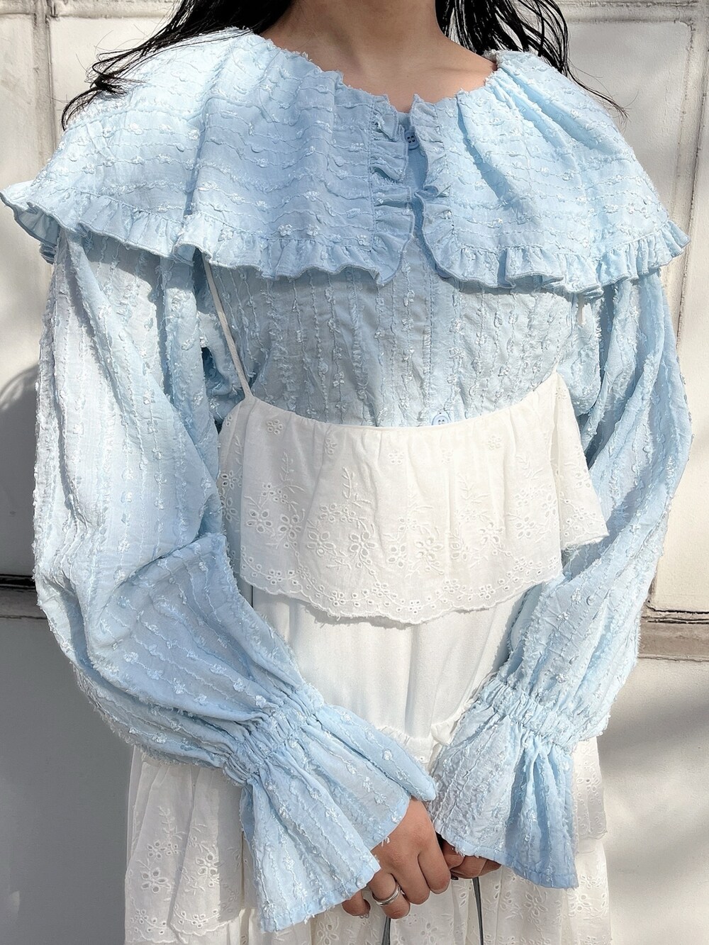 ブルー系のシャツ/ブラウス、ブルー系のショルダーバッグ、ホワイト系のワンピースを着用したレディースの冬コーディネートの7枚目の写真