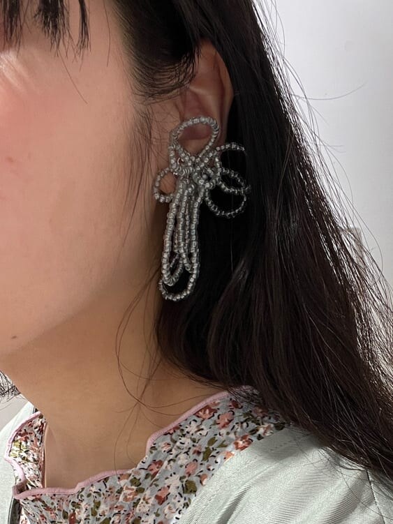 グリーン系のカーディガン/ボレロ、グリーン系のスカート、グリーン系のパンプスを着用したレディースの春コーディネートの6枚目の写真