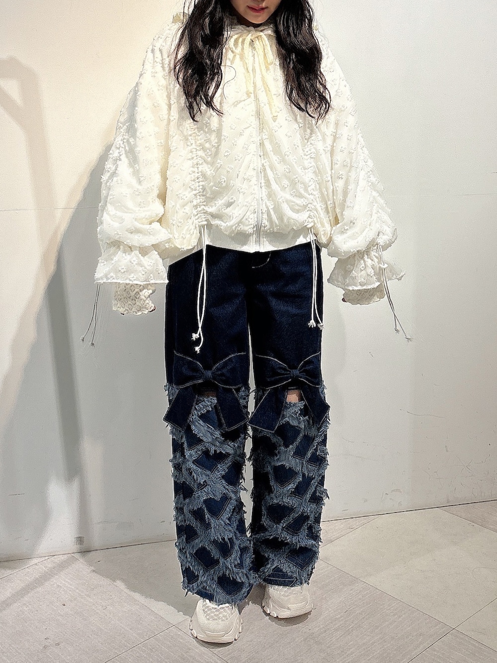 ホワイト系のジャージ、ブルー系のデニムパンツ、ホワイト系のスニーカーを着用したレディースの秋コーディネートの2枚目の写真