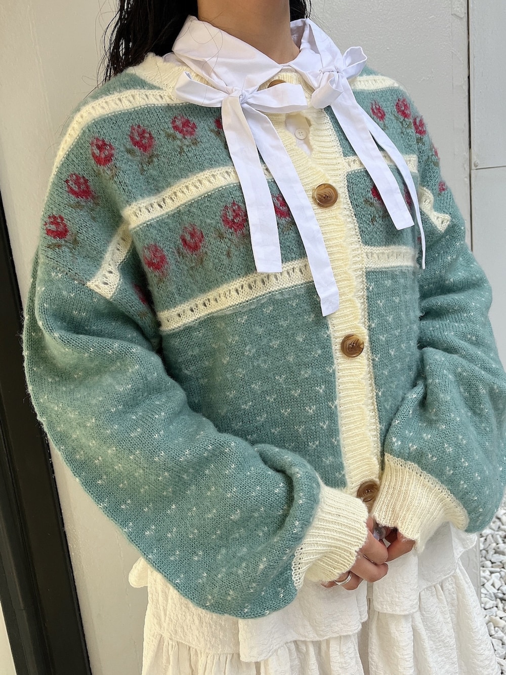 グリーン系のカーディガン/ボレロ、ホワイト系のシャツ/ブラウス、ホワイト系のスカートを着用したレディースの秋コーディネートの5枚目の写真