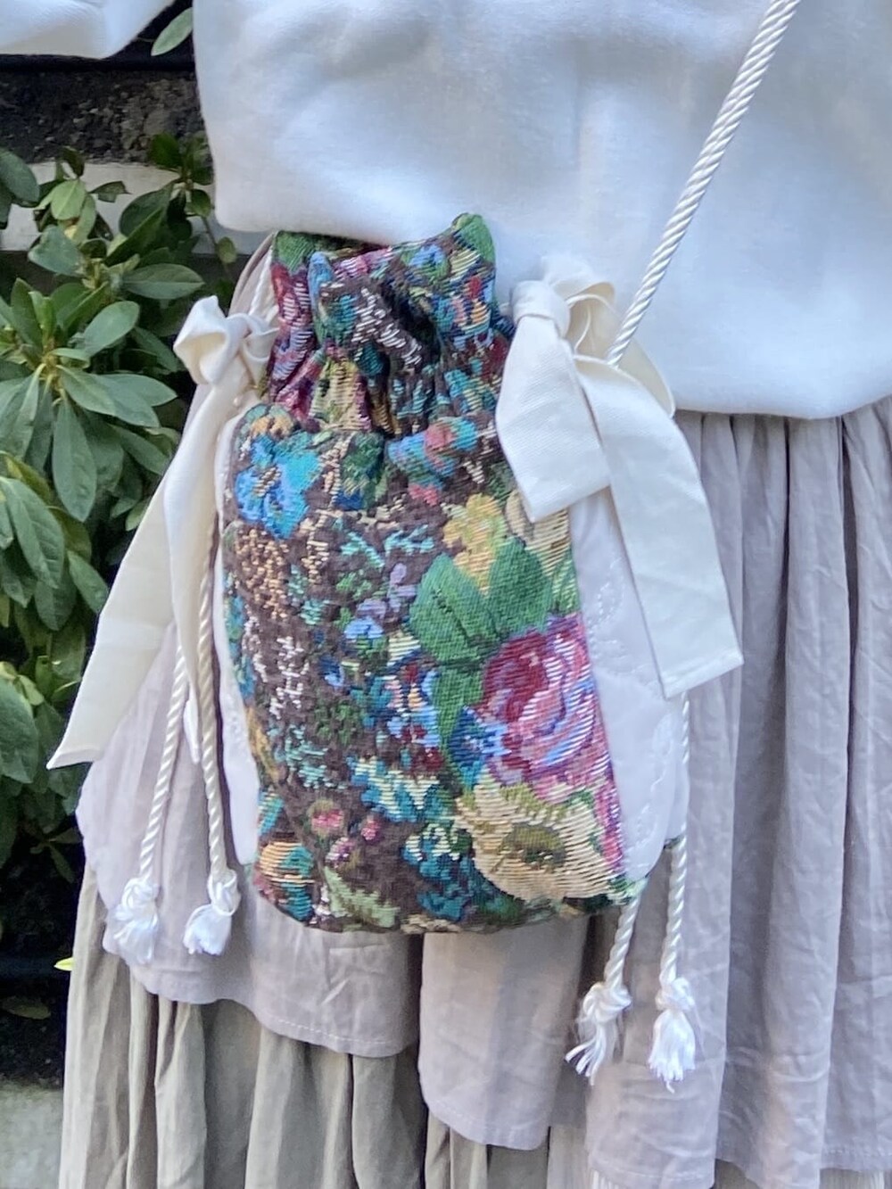 ブラウン系のスカート、ゴールド系のその他シューズ、ホワイト系のニット/セーターを着用したレディースの秋コーディネートの6枚目の写真