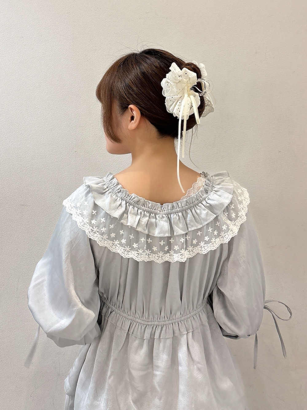 ブルー系のワンピース、ブルー系のハンドバッグ、ブルー系のデニムパンツを着用したレディースの夏コーディネートの6枚目の写真