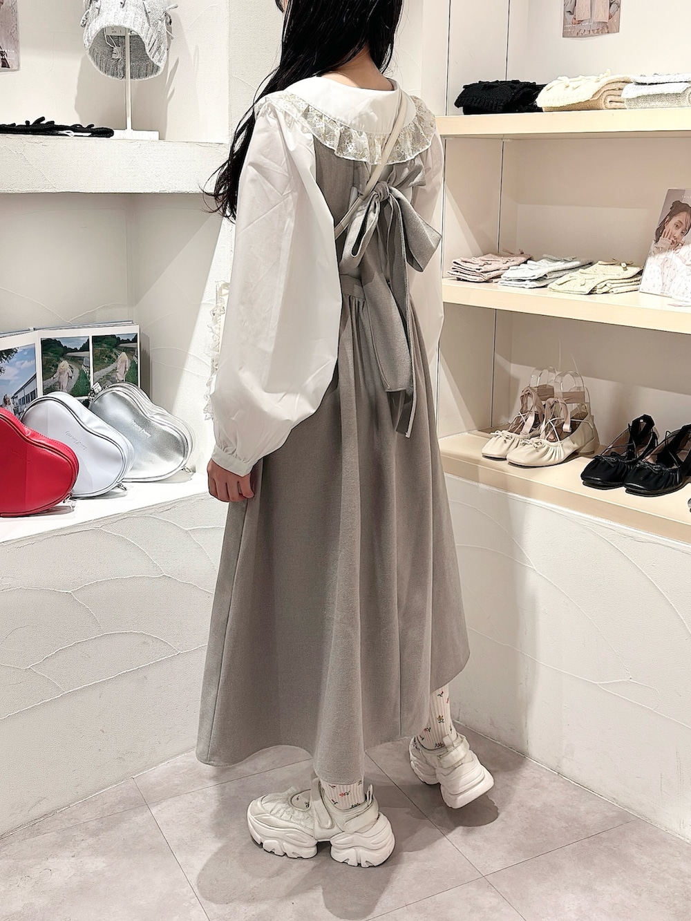 ゴールド系のシャツ/ブラウス、グレー系のワンピース、ホワイト系のショルダーバッグを着用したレディースの秋コーディネートの3枚目の写真