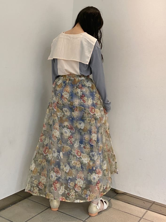 イエロー系のスカート、ベージュ系のパンプス、ブルー系のTシャツ/カットソーを着用したレディースの夏コーディネートの3枚目の写真