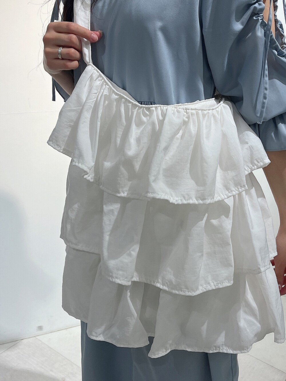 ブルー系のワンピース、ホワイト系のパンプス、ホワイト系のニット/セーターを着用したレディースの春コーディネートの7枚目の写真