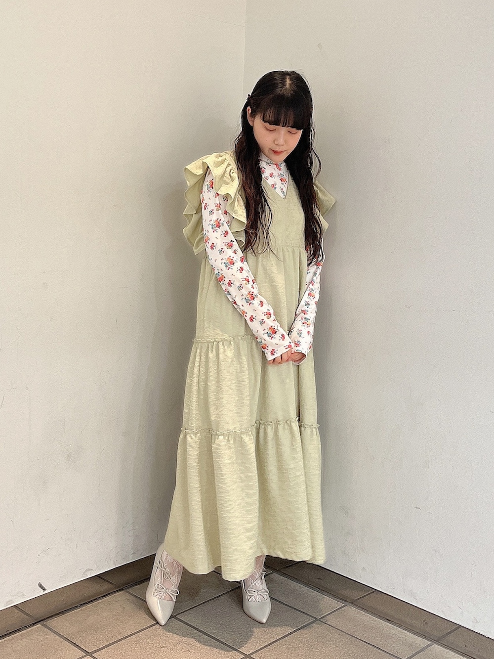 グリーン系のワンピース、ホワイト系のパンプス、ホワイト系のTシャツ/カットソーを着用したレディースの冬コーディネートの2枚目の写真