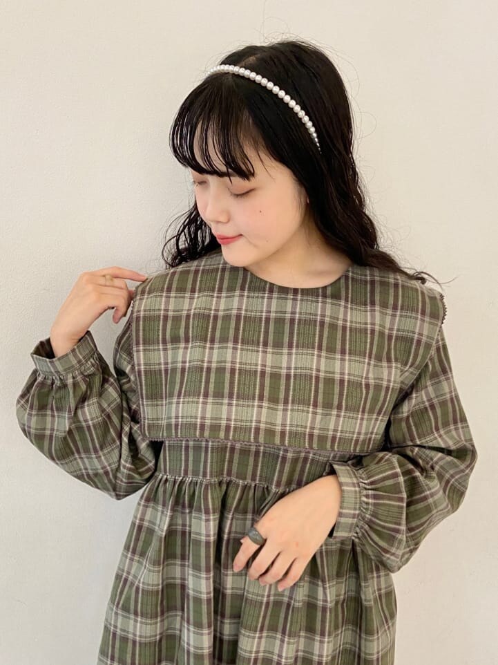 グリーン系のワンピース、ホワイト系のその他シューズ、ホワイト系のショルダーバッグを着用したレディースの秋コーディネートの3枚目の写真