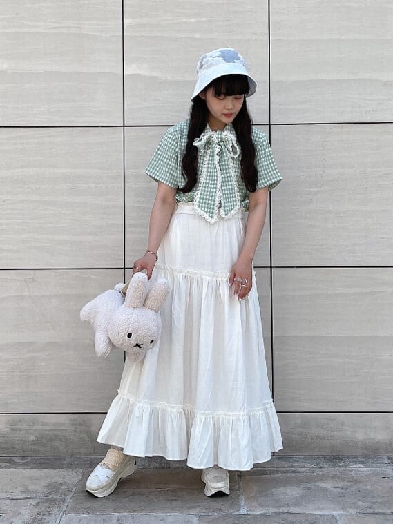 ホワイト系のハンドバッグ、グリーン系のシャツ/ブラウス、ホワイト系のスカートを着用したレディースの夏コーディネートの2枚目の写真