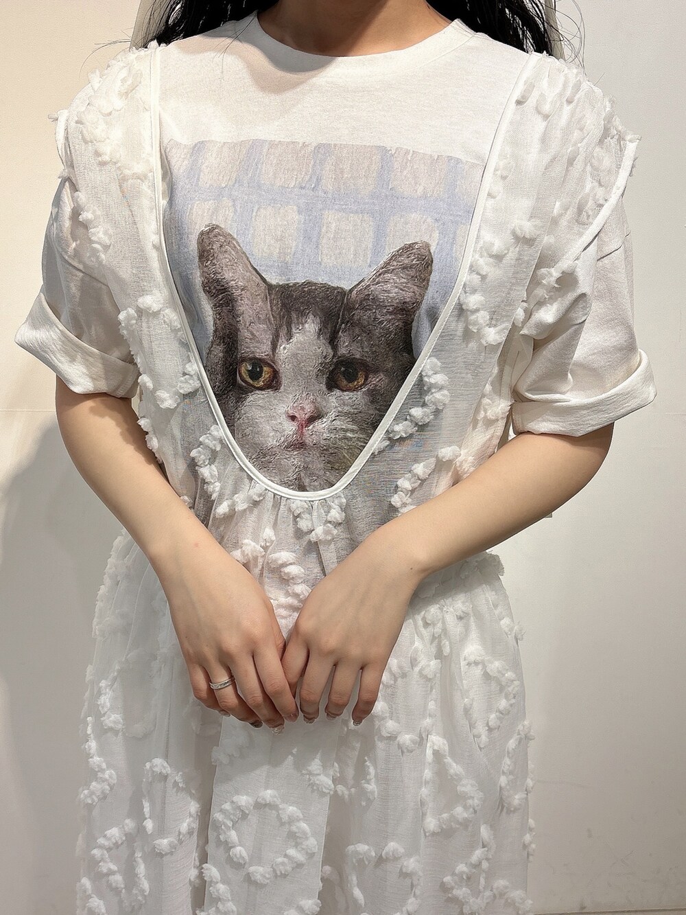 ホワイト系のTシャツ/カットソー、ホワイト系のジャンパースカート、ホワイト系のスニーカーを着用したレディースの春コーディネートの6枚目の写真