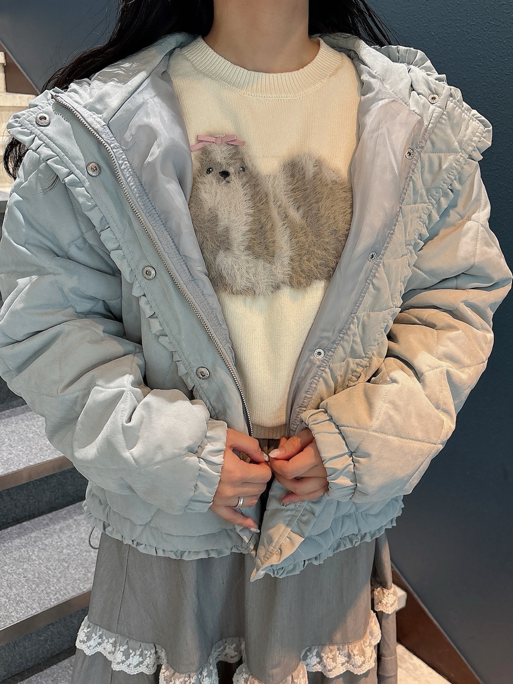 ブルー系のダウンジャケット/コート、ホワイト系のニット/セーター、グレー系のスカートを着用したレディースの秋コーディネートの8枚目の写真