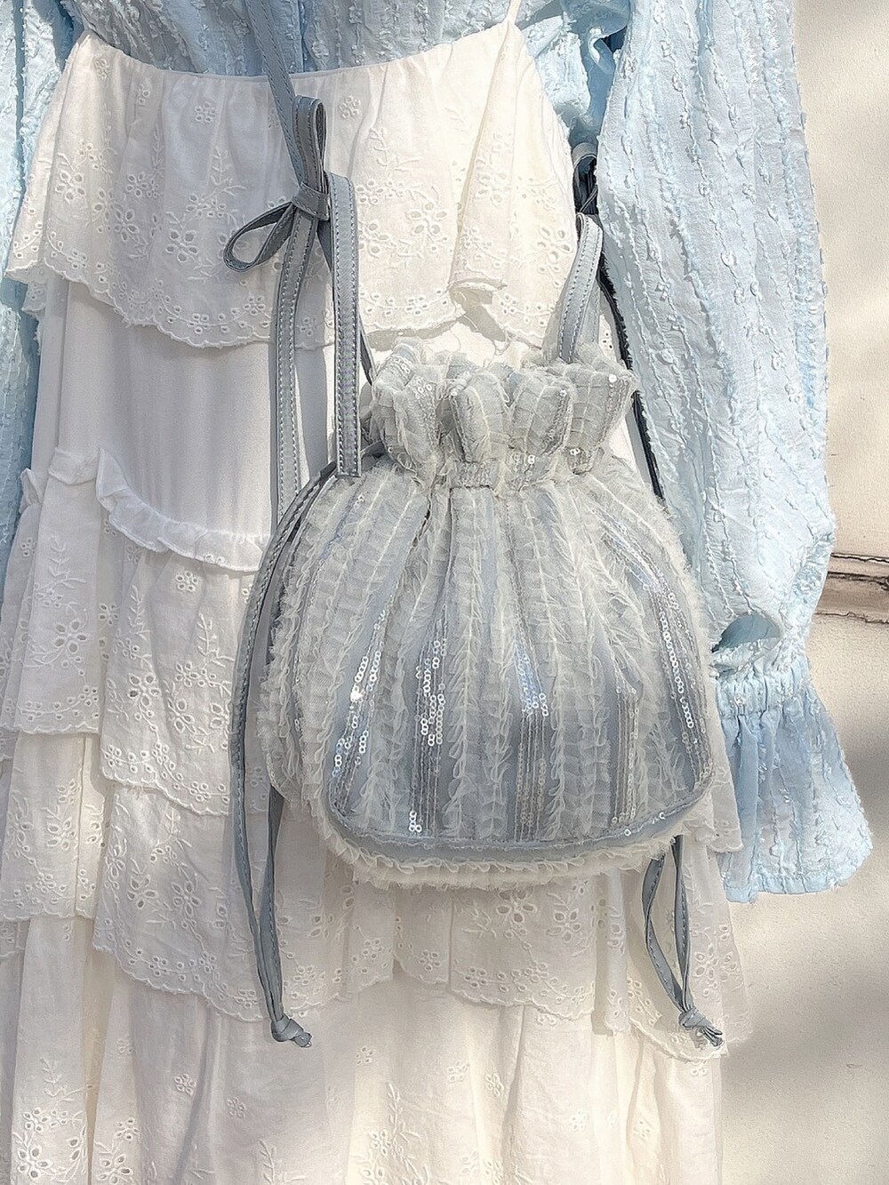 ブルー系のシャツ/ブラウス、ブルー系のショルダーバッグ、ホワイト系のワンピースを着用したレディースの冬コーディネートの8枚目の写真