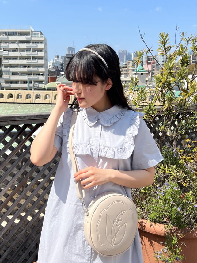 ホワイト系のスニーカー、ホワイト系のショルダーバッグ、ブルー系のワンピースを着用したレディースの春コーディネートの2枚目の写真