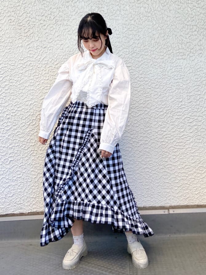 ブルー系のステンカラーコート、ホワイト系のシャツ/ブラウス、ブラック系のスカートを着用したレディースの秋コーディネートの6枚目の写真