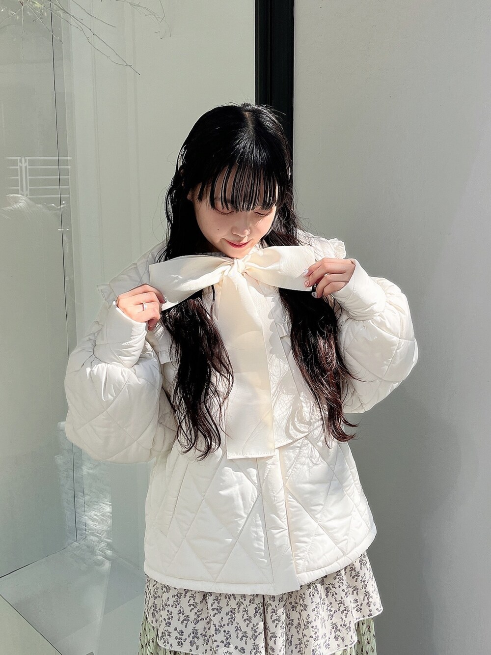 ホワイト系のダウンジャケット/コート、グリーン系のスカート、ホワイト系のスニーカーを着用したレディースの冬コーディネートの6枚目の写真