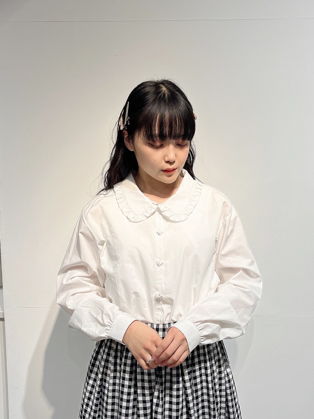 ホワイト系のシャツ/ブラウス、ブラック系のスカート、ホワイト系のパンプスを着用したレディースの春コーディネートの5枚目の写真