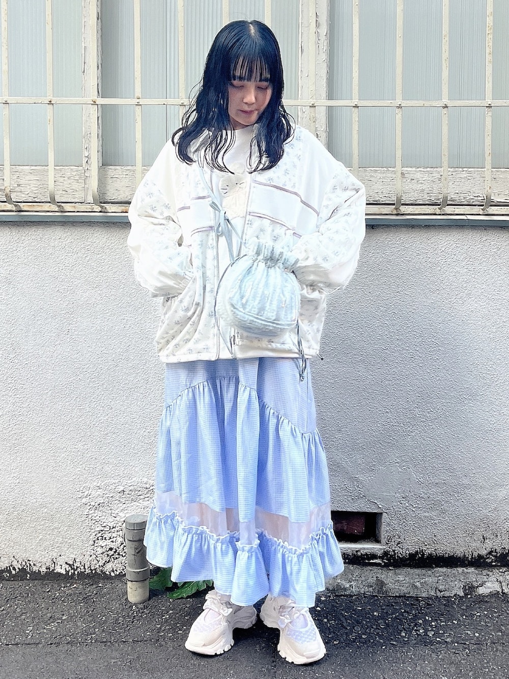 ホワイト系のスウェット、ブルー系のジャージ、ブルー系のショルダーバッグを着用したレディースの春コーディネートの2枚目の写真