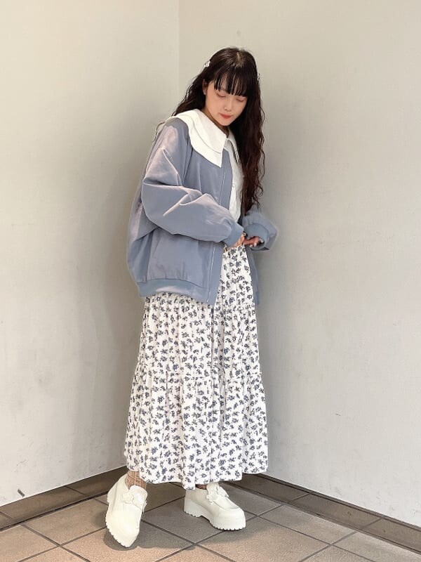 ホワイト系のパンプス、ホワイト系のスカート、ブルー系のブルゾンを着用したレディースの秋コーディネートの2枚目の写真