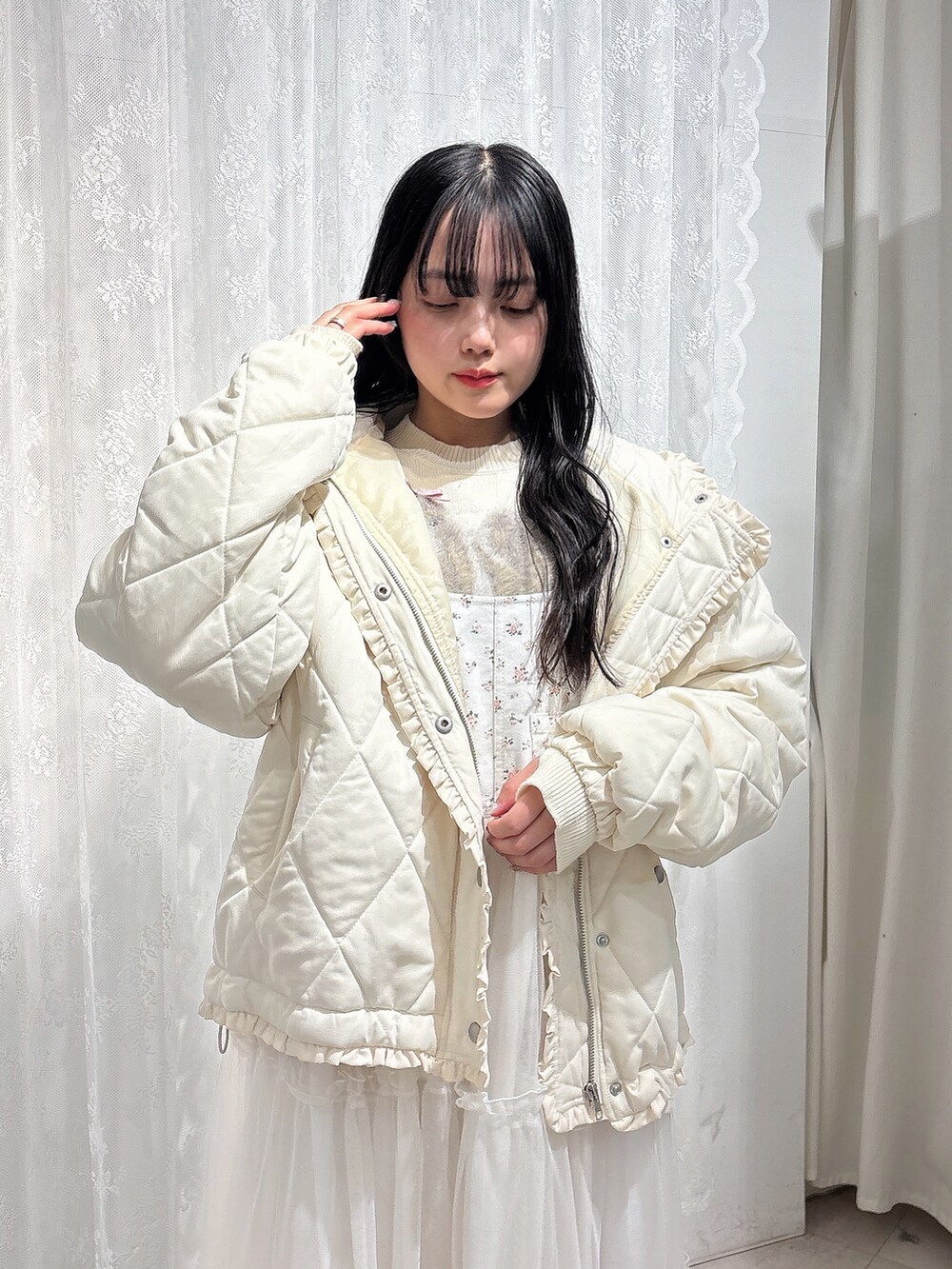 ホワイト系のニット/セーター、ホワイト系のダウンジャケット/コート、ホワイト系のワンピースを着用したレディースの冬コーディネートの6枚目の写真