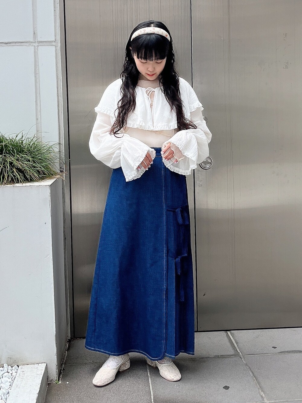 ベージュ系のTシャツ/カットソー、ホワイト系のシャツ/ブラウス、ブルー系のデニムスカートを着用したレディースの夏コーディネートの2枚目の写真