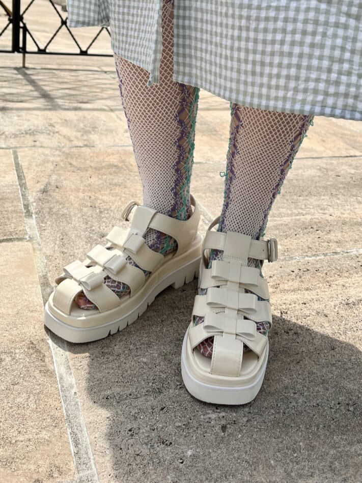 グリーン系のワンピース、ホワイト系のサンダル、ホワイト系のショルダーバッグを着用したレディースの春コーディネートの6枚目の写真