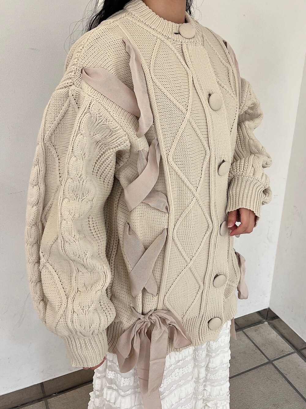 ホワイト系のニット/セーター、ホワイト系のスカート、ホワイト系のブーツを着用したレディースの秋コーディネートの5枚目の写真