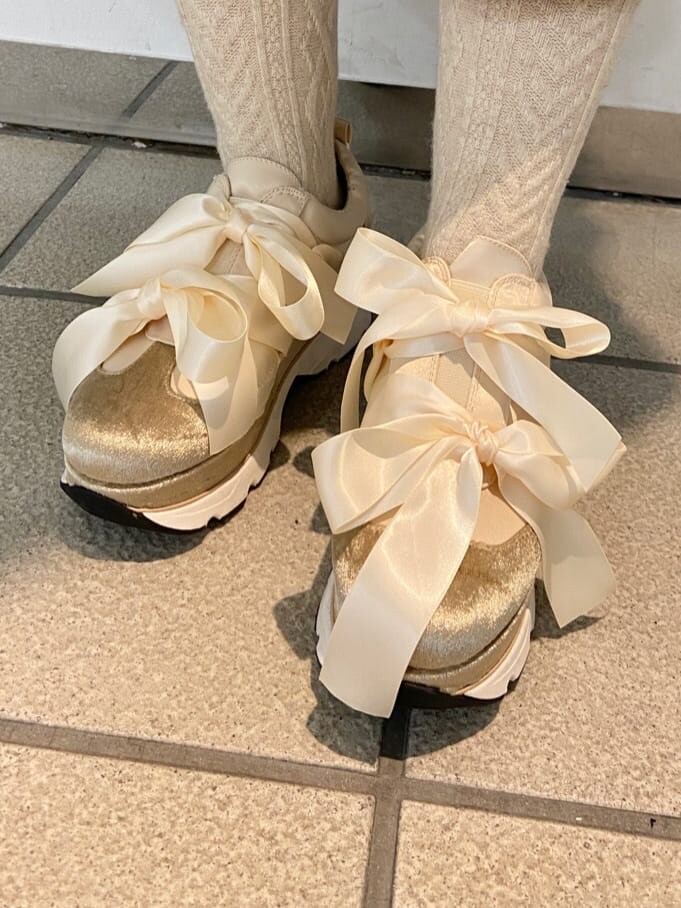 ホワイト系のブルゾン、ブラック系のワンピース、ホワイト系のスニーカーを着用したレディースの冬コーディネートの7枚目の写真