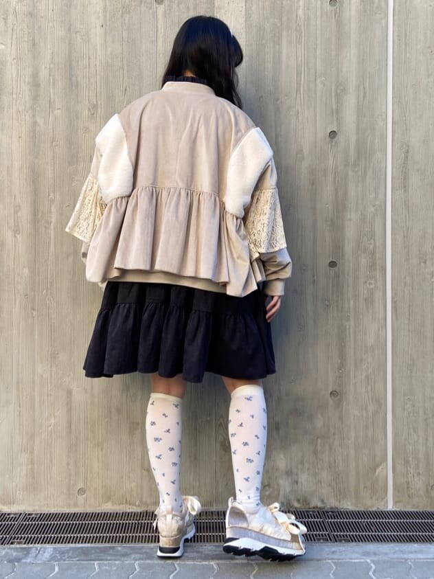 ホワイト系のブルゾン、ブラック系のワンピース、ホワイト系のスニーカーを着用したレディースの冬コーディネートの3枚目の写真