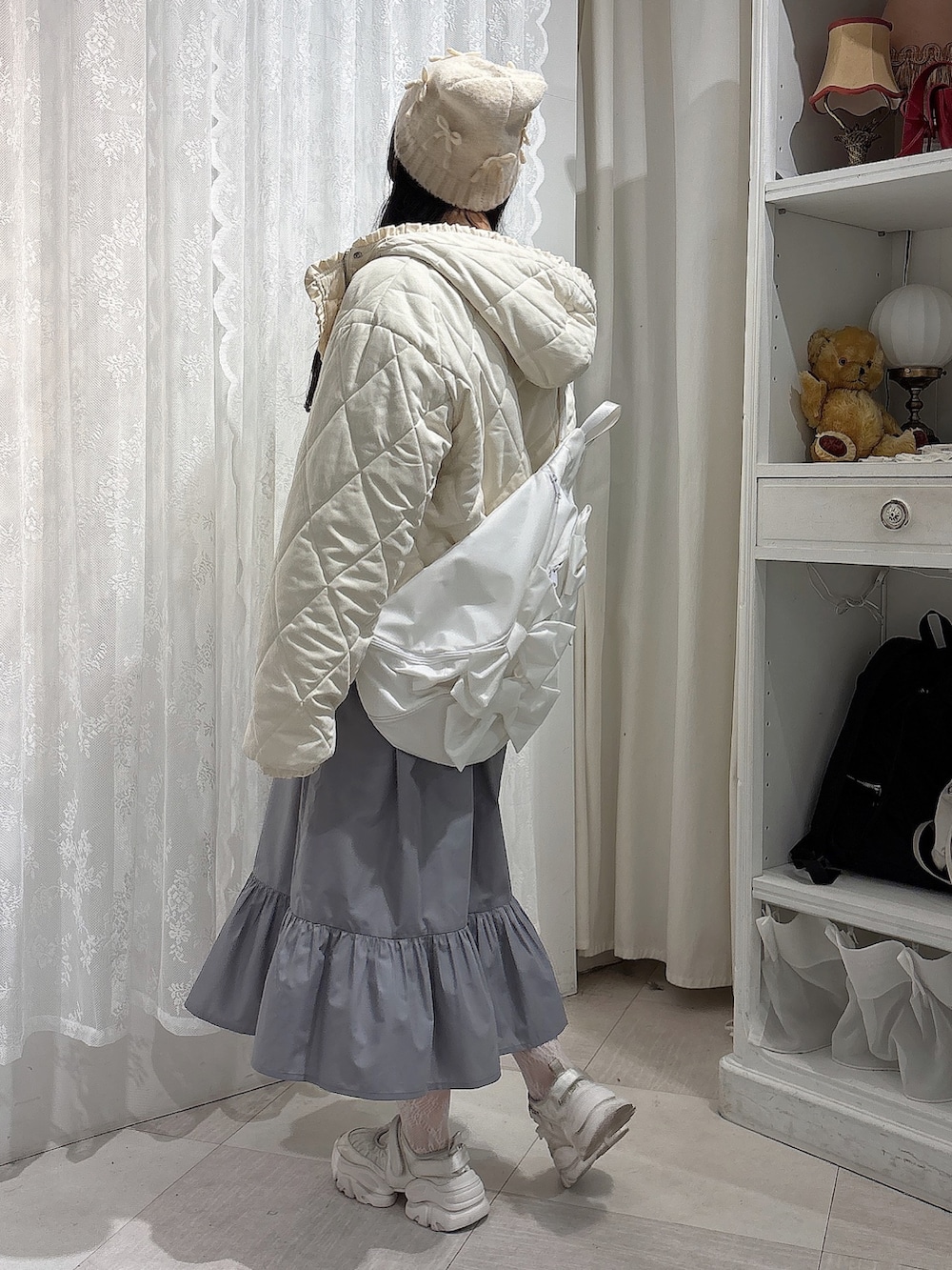 グレー系のスウェット、ホワイト系のダウンジャケット/コート、ホワイト系のショルダーバッグを着用したレディースの冬コーディネートの3枚目の写真