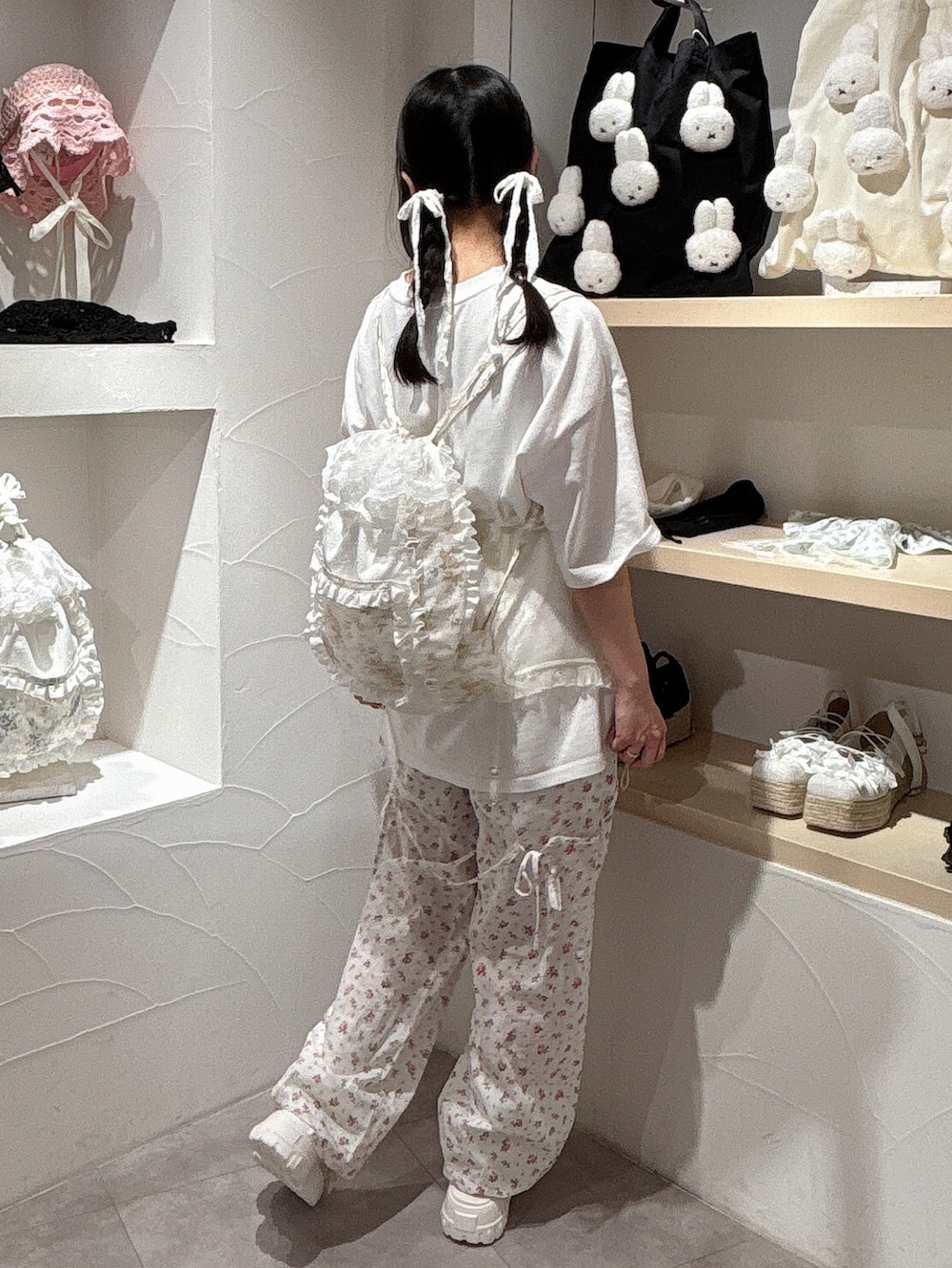 ホワイト系のTシャツ/カットソー、イエロー系のバックパック/リュック、ホワイト系のスラックスを着用したレディースの夏コーディネートの5枚目の写真