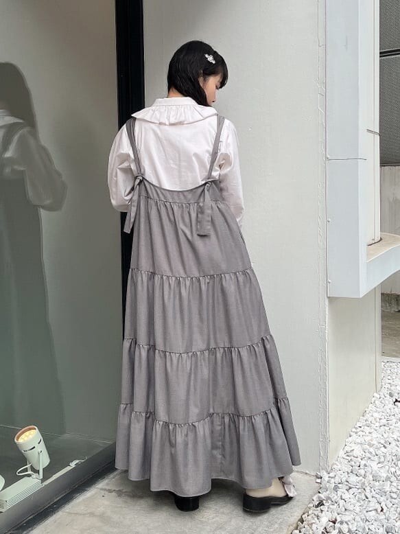 グリーン系のノーカラーコート、ホワイト系のシャツ/ブラウス、ホワイト系のモカシン/デッキシューズを着用したレディースの秋コーディネートの5枚目の写真