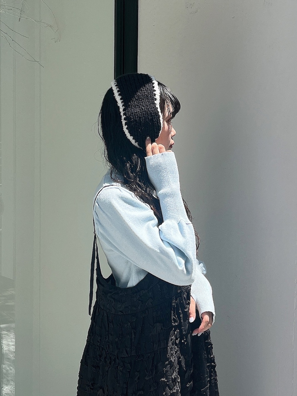 ブルー系のニット/セーター、ブラック系のワンピース、ホワイト系のスリッポンを着用したレディースの夏コーディネートの7枚目の写真