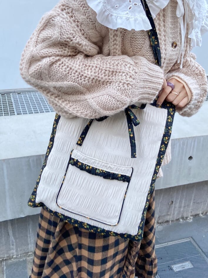 オレンジ系のスカート、ベージュ系のパンプス、ホワイト系のトートバッグを着用したレディースの秋コーディネートの6枚目の写真