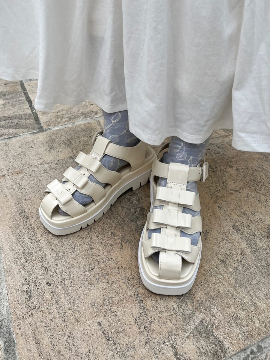 ホワイト系のワンピース、ホワイト系のサンダル、ブルー系のトートバッグを着用したレディースの春コーディネートの4枚目の写真