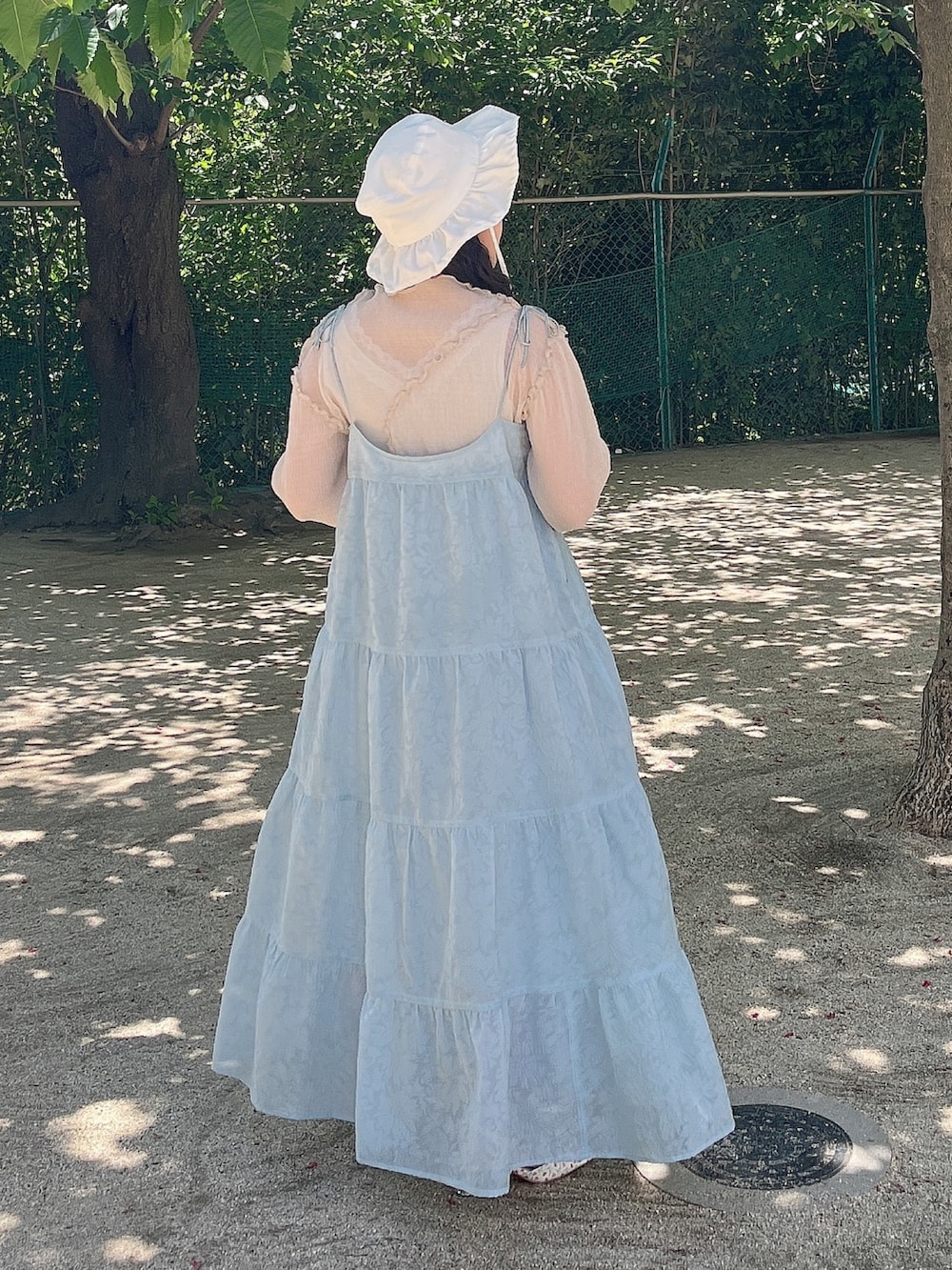 ブルー系のワンピース、ベージュ系のTシャツ/カットソー、ホワイト系のパンプスを着用したレディースの夏コーディネートの3枚目の写真