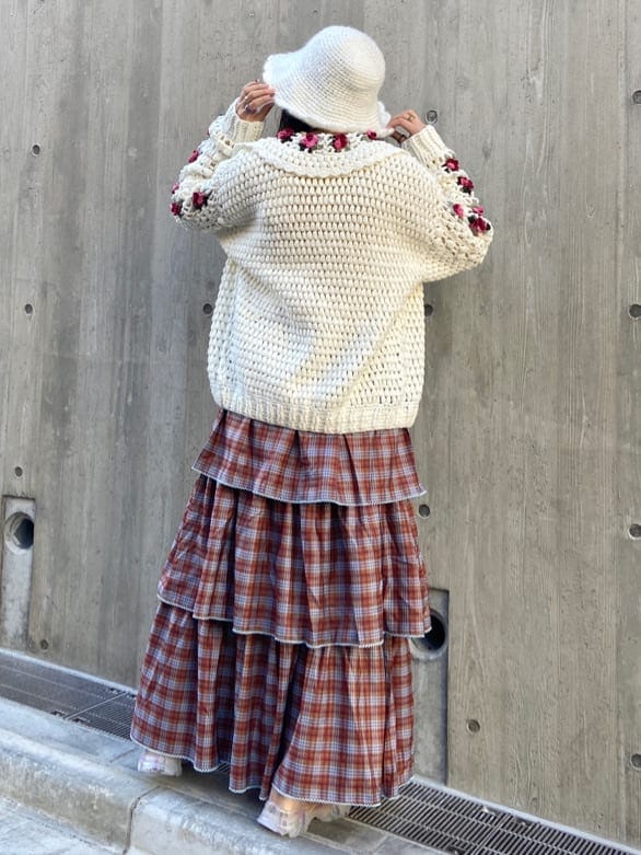 オレンジ系のスカート、オレンジ系のスニーカー、ホワイト系のニット/セーターを着用したレディースの秋コーディネートの3枚目の写真