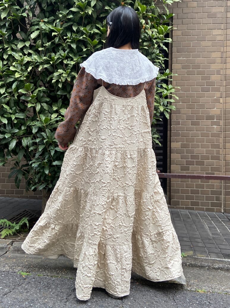 ベージュ系のワンピース、ホワイト系のシャツ/ブラウス、ホワイト系のローファーを着用したレディースの秋コーディネートの3枚目の写真