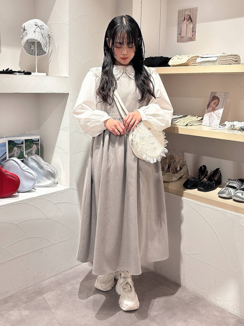 ゴールド系のシャツ/ブラウス、グレー系のワンピース、ホワイト系のショルダーバッグを着用したレディースの秋コーディネートの2枚目の写真