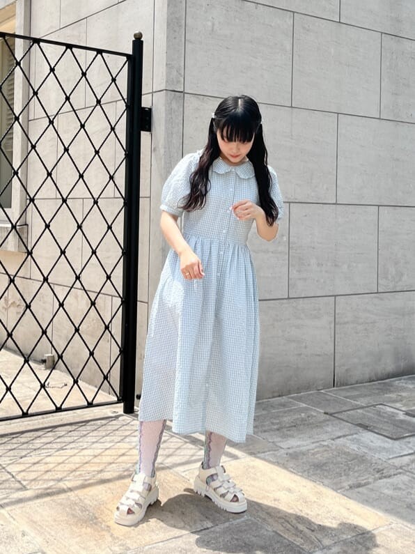 グリーン系のワンピース、ホワイト系のサンダル、ホワイト系のショルダーバッグを着用したレディースの春コーディネートの2枚目の写真