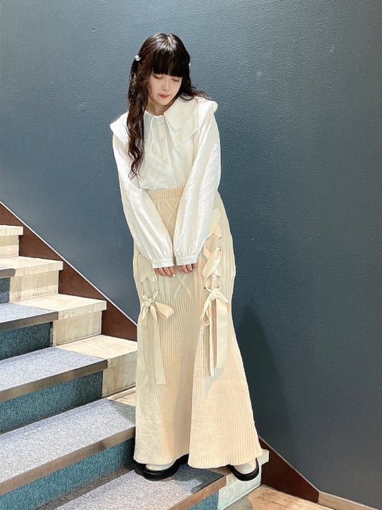 ホワイト系のブーツ、グリーン系のその他アウター、ホワイト系のスカートを着用したレディースの秋コーディネートの4枚目の写真