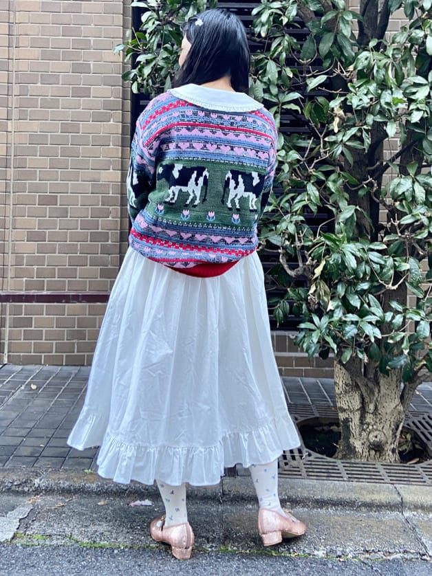 ベージュ系のパンプス、レッド系のニット/セーター、ホワイト系のワンピースを着用したレディースの冬コーディネートの3枚目の写真